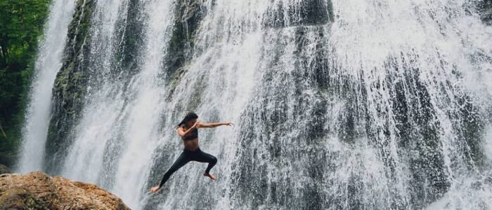 Chica Vida Lotus Girl Jumping in Waterfall